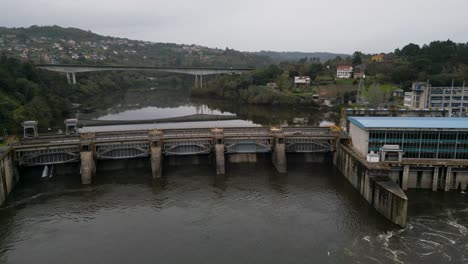 frontal wide angle view of velle water dam and power plant in ourense, galicia, spain and bridge reflection