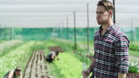 Ein-Hübscher-Junger-Mann,-Der-Während-Der-Arbeit-Wasser-Trinkt