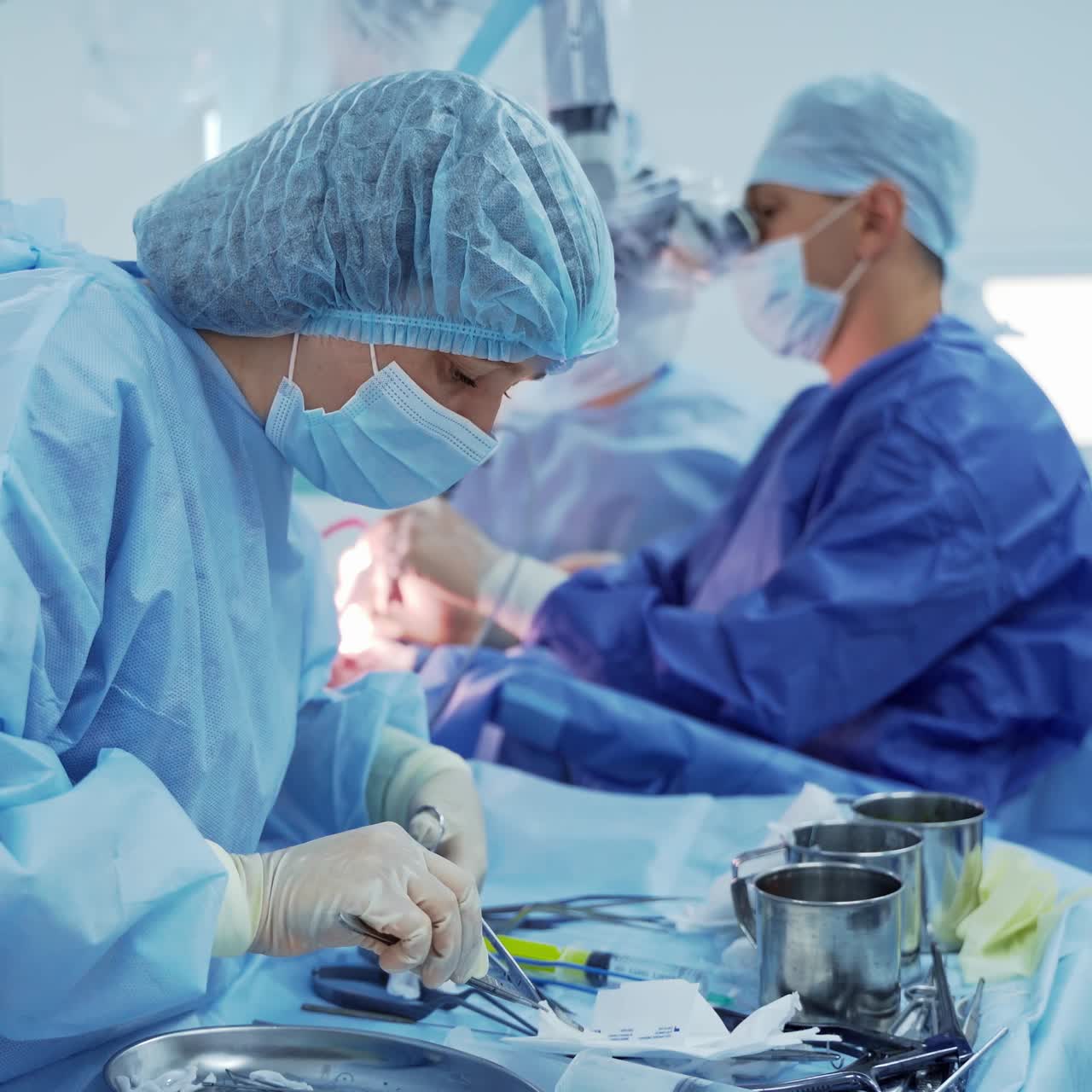 Group of doctors during neurosurgery. Medical assistant works with sterile instruments on the background of neurosurgical process. Healthcare.