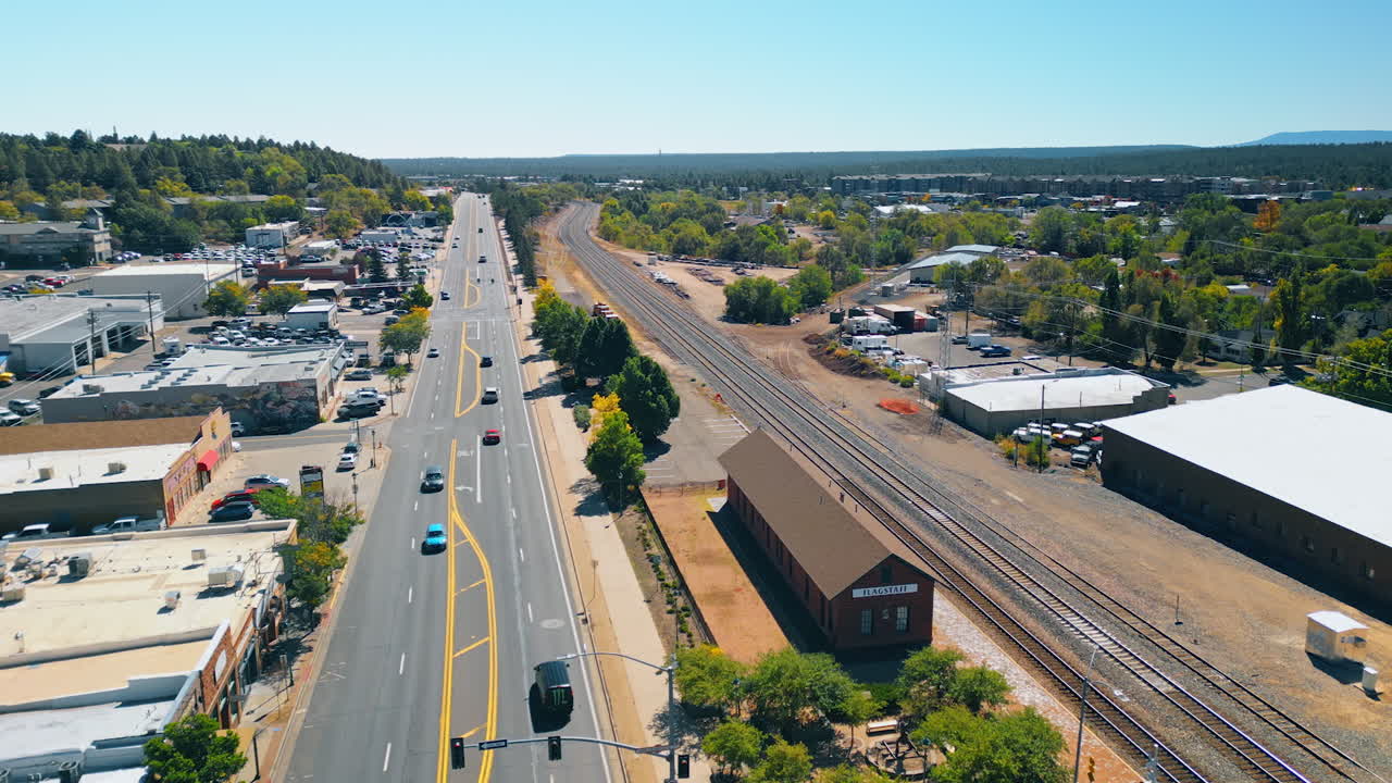 Flagstaff, USA, 24 August 2025: Cars ride by the wide highway along the railways. Drone flight above Flagstaff, Arizona, USA