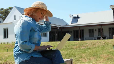 senior woman using laptop in park