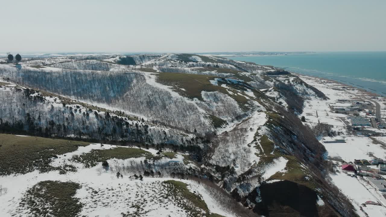 Snowy Hills And Coastal City Of Wakkanai During Winter In Hokkaido, Japan. - aerial shot