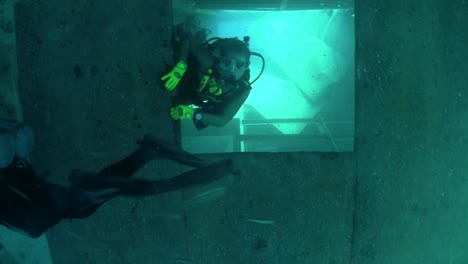 divers explore a shipwreck 1