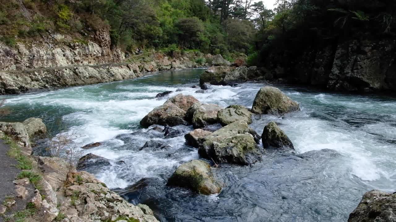 Scenic view of fast flowing white water over rocks on Ohinemuri River within Karangahake Gorge in North Island of New Zealand Aotearoa