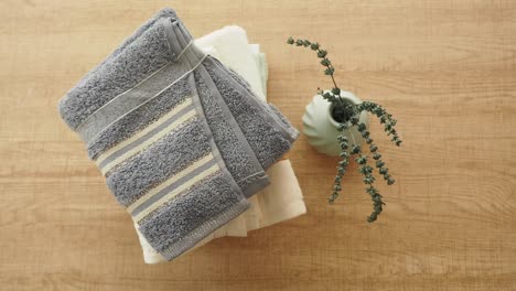 folded towels and plants on wooden table