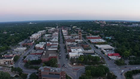 reverse pullback aerial panning shot of downtown lawrence, kansas at sunset