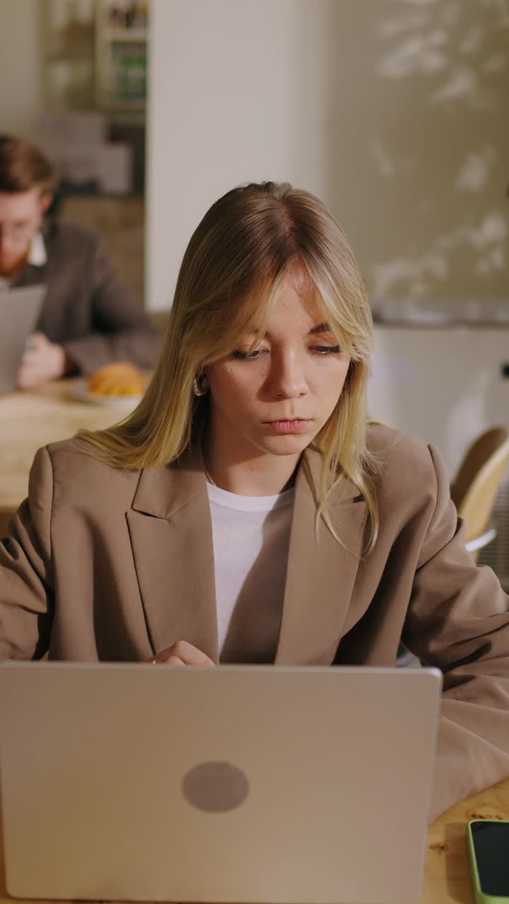 Giovane donna d'affari che lavora al laptop in un ufficio moderno