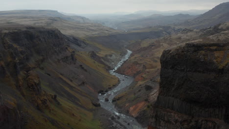 Birds-eye-stunning-and-surreal-landscape-of-Haifoss-valley-in-Iceland-with-river-Fossa-flowing-on-riverbed.-Aerial-view-moonscape-countryside-with-basalt-rock-formation.-Beauty-on-earth