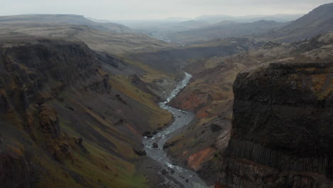 Ojo-De-Pájaro-Paisaje-Impresionante-Y-Surrealista-Del-Valle-De-Haifoss-En-Islandia-Con-Fosa-De-Río-Que-Fluye-En-El-Lecho-Del-Río.-Vista-Aérea-Del-Paisaje-Lunar-Con-Formación-De-Roca-Basáltica.-Belleza-En-La-Tierra