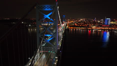 traffic crosses suspension bridge at night