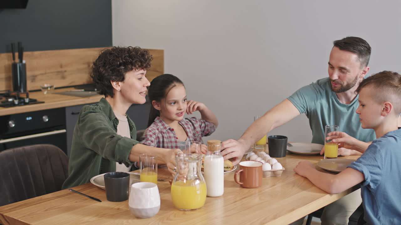 Familia encantada desayunando con sus dos hijos