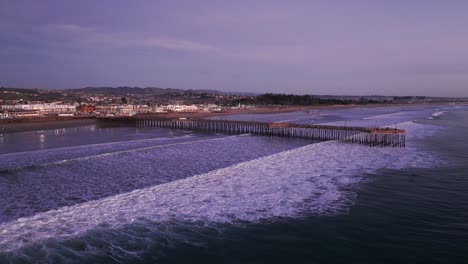 Dramatische-Drohnenaufnahme-Eines-Flugs-Zum-Pismo-Beach-Pier-Bei-Sonnenuntergang