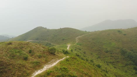 expansive white gravel path between the hilly green low vegetated hills of ling wui shan hill in hong kong china