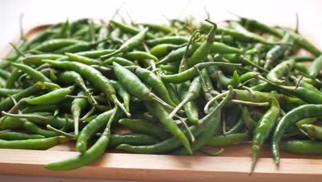 Close-up-of-green-chili-on-wooden-board-,