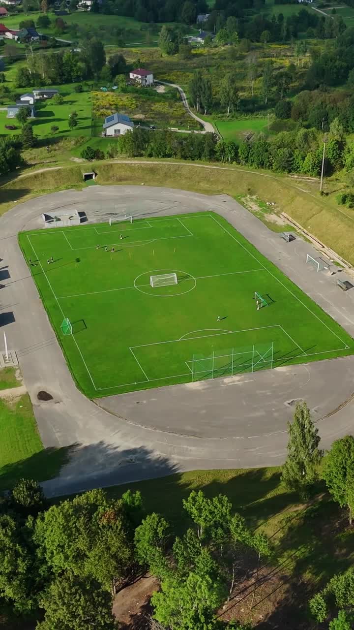 Vertical aerial view of a soccer field in Talsi, Latvia, surrounded by lush natural scenery