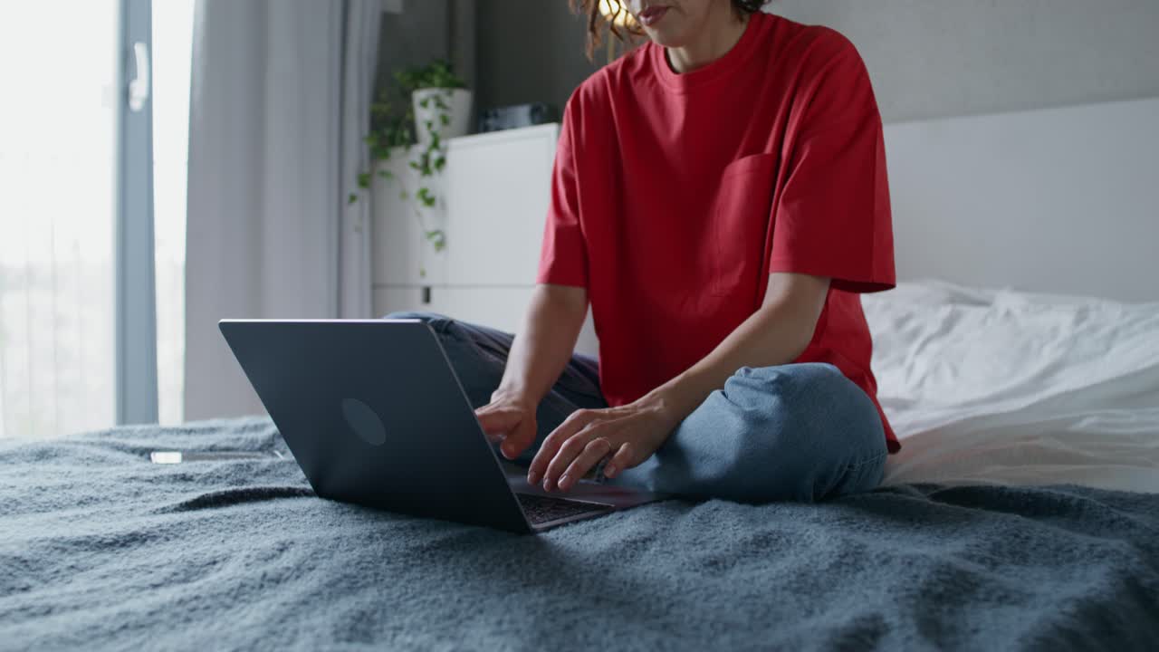 mujer trabajando en una computadora portátil en la cama