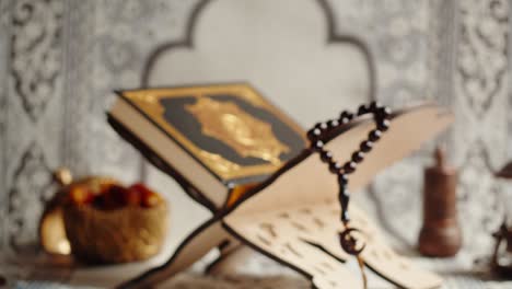 holy quran on rehal with prayer beads and dates
