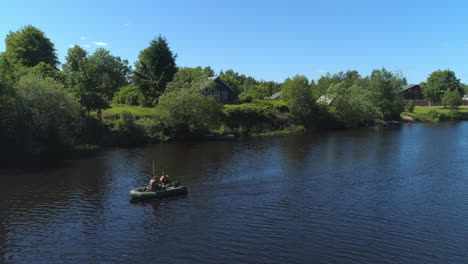 fishing on a river with wooden houses and trees