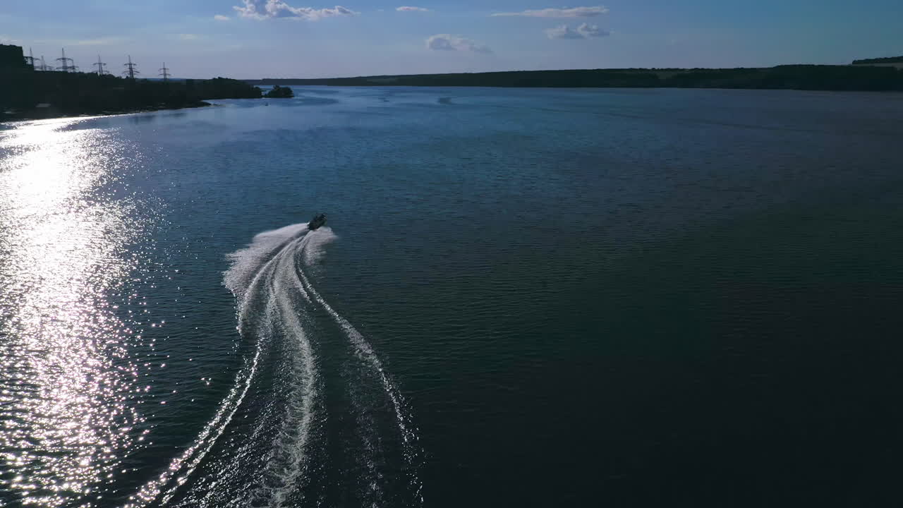 Boat with people floating on river. Aerial drone shot of sailing motor ship in the middle of river