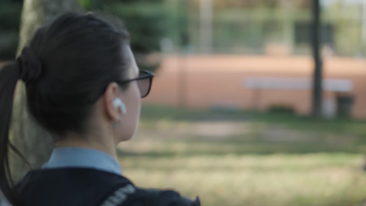 Jovem mulher com raquete de tênis no parque