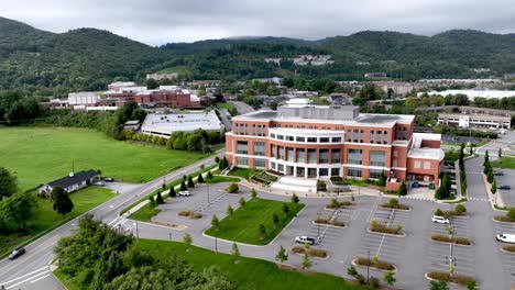 Retirada-Aérea-Sobre-El-Edificio-Médico-De-La-Universidad-Estatal-De-Los-Apalaches-Con-El-Sistema-De-Salud-De-Los-Apalaches-Al-Fondo-En-Boone-Carolina-Del-Norte,-Carolina-Del-Norte