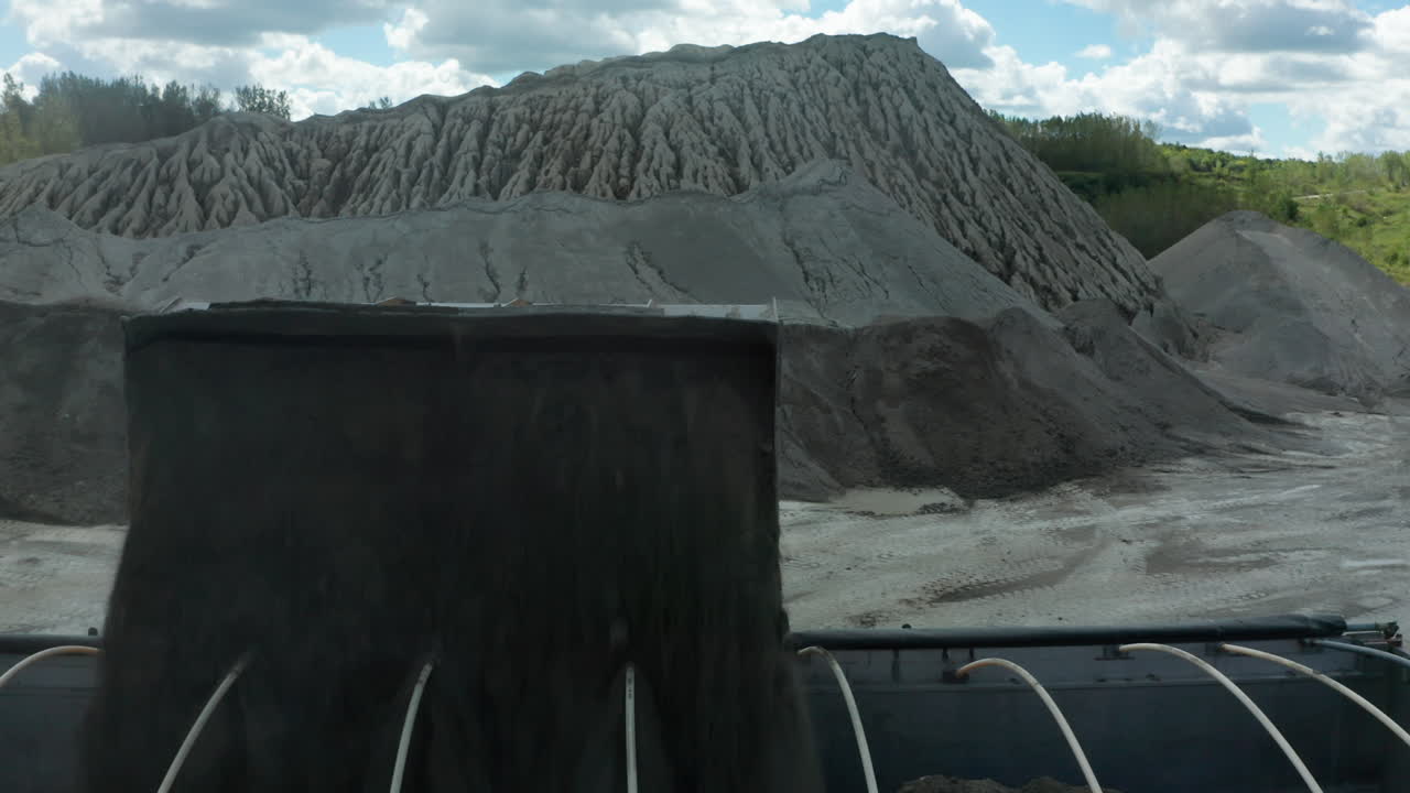 disparo ascendente de un cargador delantero vertiendo piedra caliza en un camión volquete en la cantera