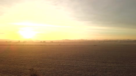 drone flies over field boundary towards beautiful warm sun rise