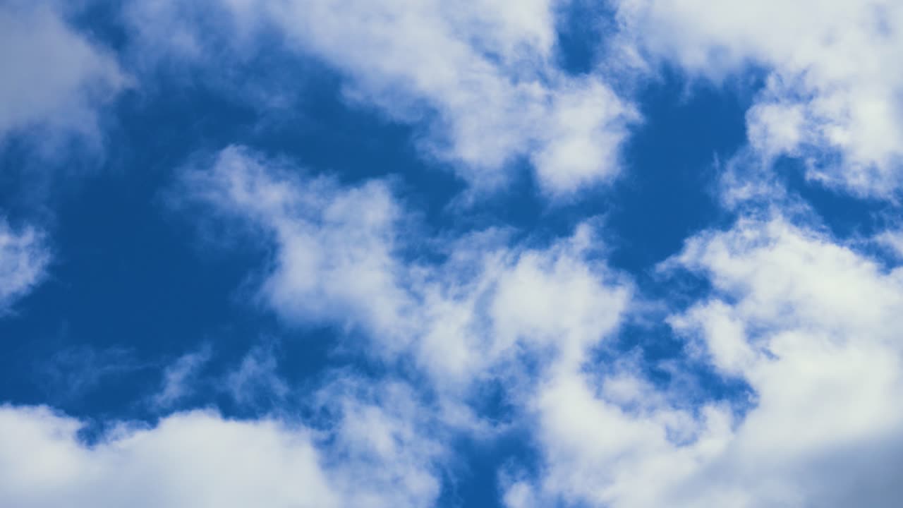 Beautiful Slow Moving Timelapse of White Cumulus Clouds Passing with Colorful Bright Blue Sky Background. Hypnotic Nature Footage.