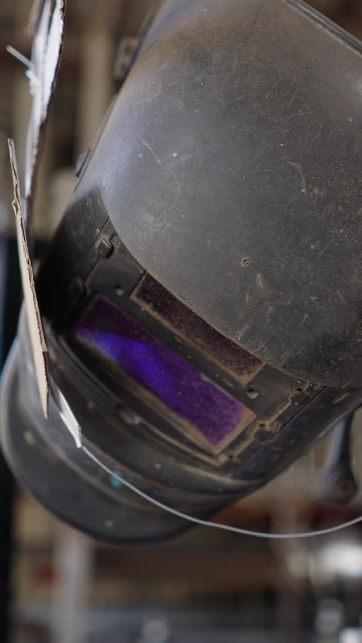 Close-up of a dirty welding helmet with a purple visor
