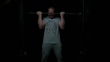 man weightlifting in dark gym
