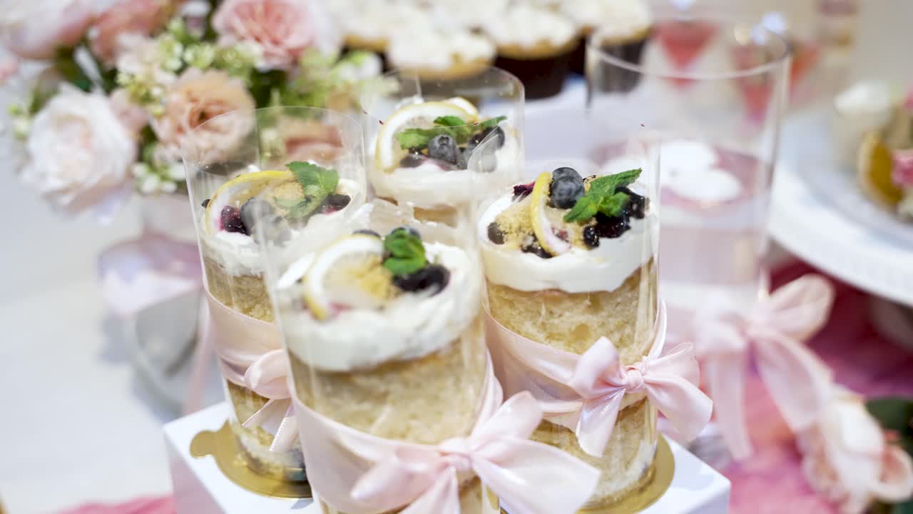 Individuelle kager med fløde, blåbær og citronskiver, der dekorerer et dessertbord til et arrangement