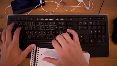 el joven está escribiendo un texto en su computadora usando un teclado-4