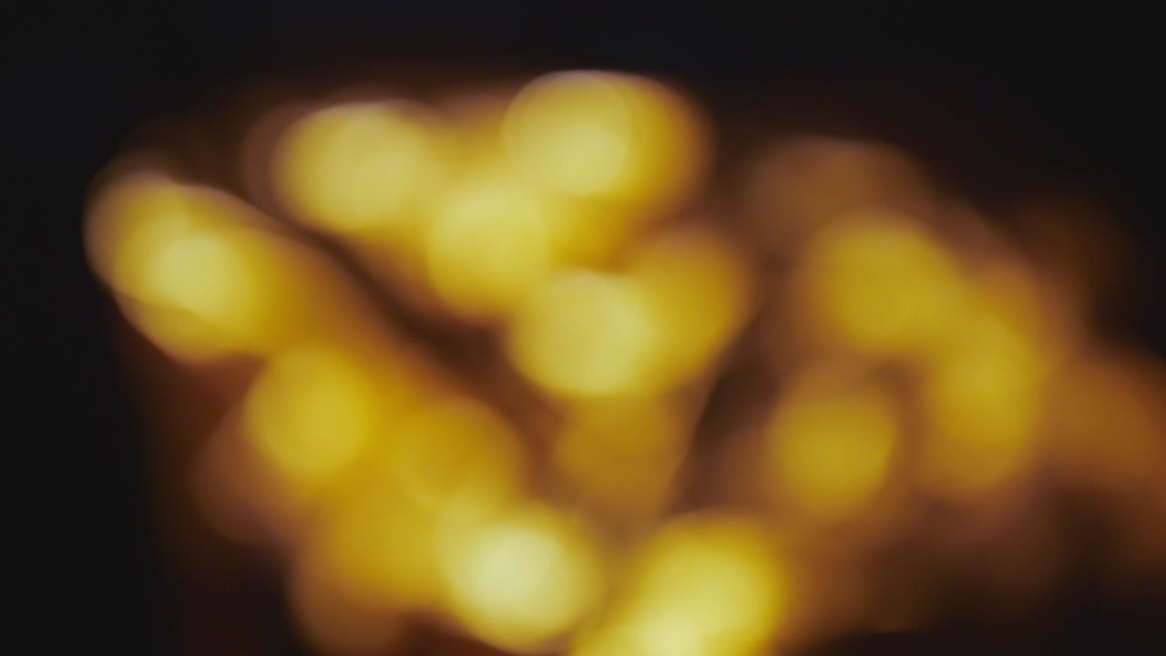 fuego, leña ardiente. regalía de alta calidad stock 4k imágenes desenfocada luz de hoguera amarilla en la noche oscura. fondo borroso. leña ardiendo quemar con fuego y llamas. fuego quemar con efecto bokeh