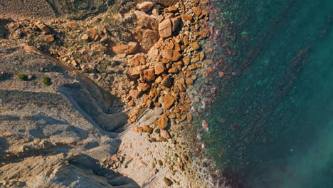 top coastal stones washed by calm turquoise ocean water in super slow motion.