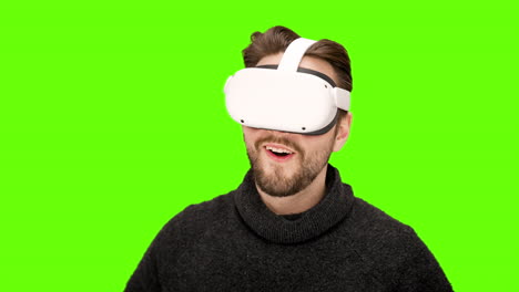 happy excited man puts on white virtual reality vr goggles first time impressive world experience headset immersive playing movie watching green screen chroma key xr augmented quest 2 technology nerd