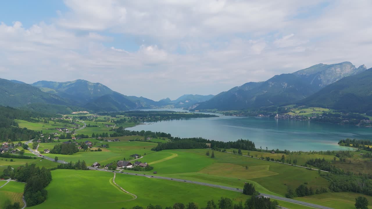 Aerial: Lake Wolfgang in the Salzburg Alps region on a sunny summer day in Austria, pull out drone shot