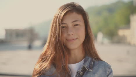 an cute teenager girl looks directly into the camera and smiles