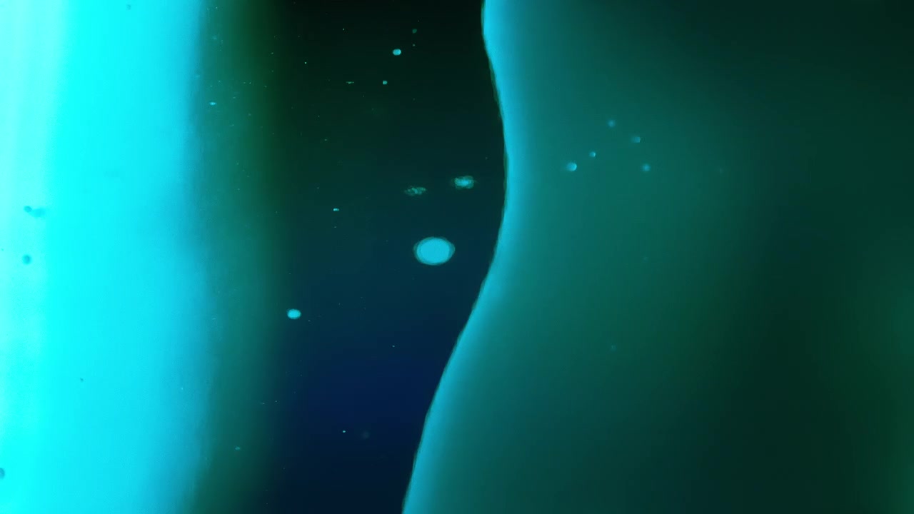 Abstract green lava bubbles floating in dark liquid. Slow motion