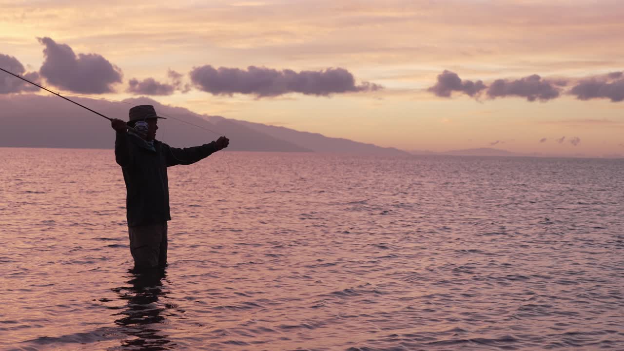 슬로우 모션은 하와이 몰로카이에서 석양의 실루엣으로 플라이 어부의 전체 샷을 보여주기 위해 사용됩니다.