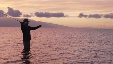 Se-Emplea-Cámara-Lenta-Para-Mostrar-Una-Toma-Completa-De-Pescador-Con-Mosca-En-Silueta-Al-Atardecer-En-Molokai,-Hawaii