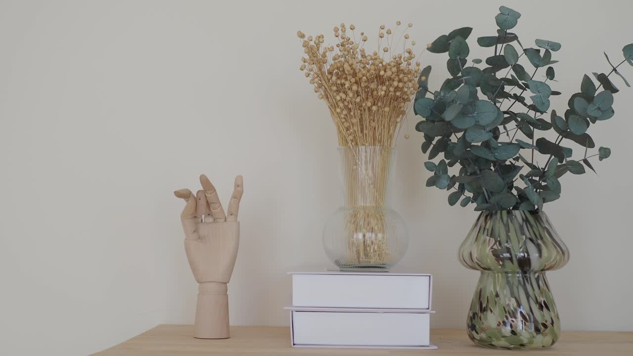 Still life with eucalyptus, dried flowers, and artificial hand