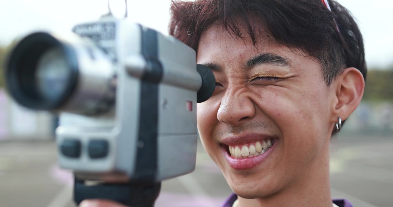 Close-up of Smiling Young Man Operating Retro Film Camera