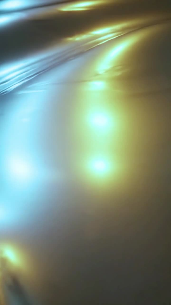 Reflejos de luz dinámicos azules y dorados moviéndose sobre una superficie