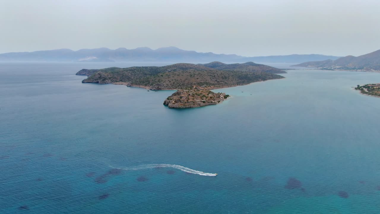 motorboat nearshore Spinalonga Island and peninsula background. Panoramic view