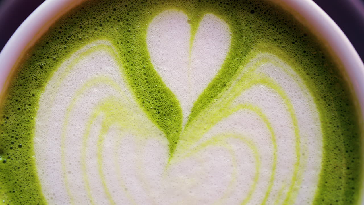 Close up of a matcha latte on a little green tray at a cafe