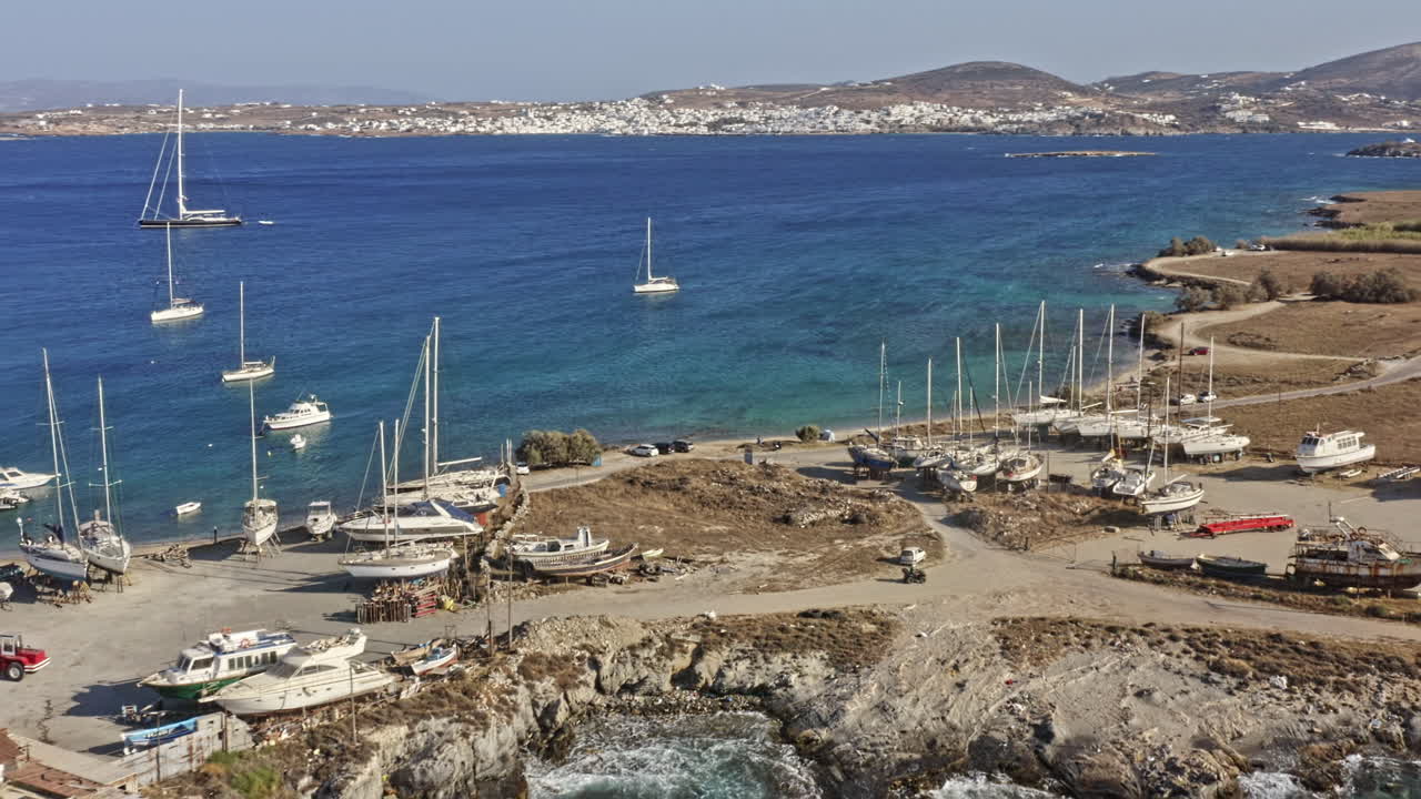 paros grecia aérea v3 toma cinematográfica de vuelo con yates y transbordadores estacionados tanto en el patio de tierra como en el golfo del océano bajo un día soleado y pacífico en el parque de paros - septiembre de 2021