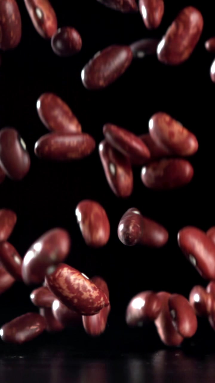 Red Kidney Beans Falling in Slow Motion on a Black Background