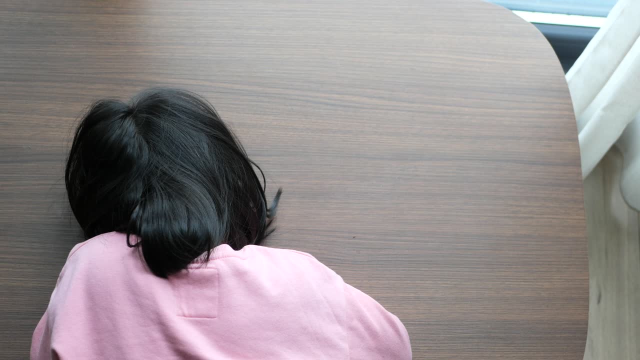 아이의 머리가 테이블 위에 내려져 있습니다.