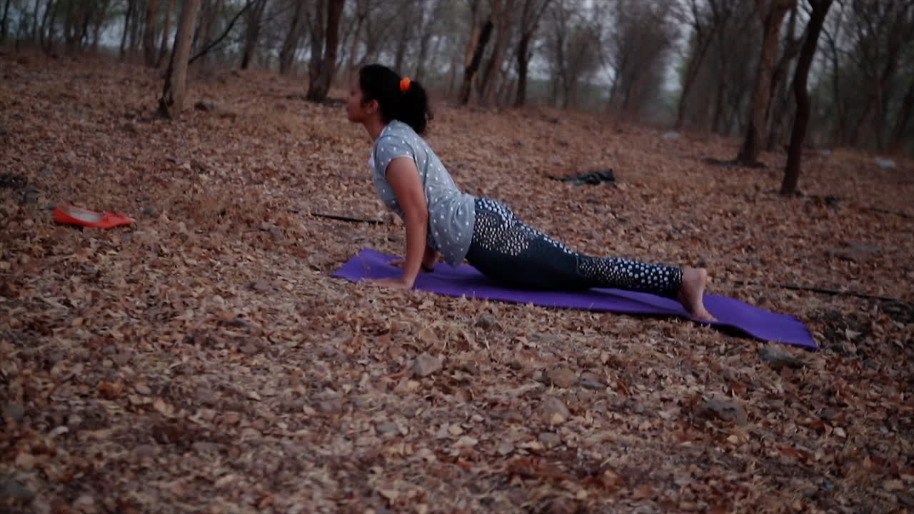 junge frau macht morgens yoga in einem park in der nähe des flusses, blendenfleck und schöner aussichtshintergrund