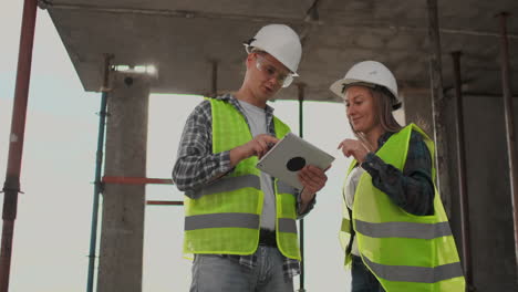 Engineers-or-architects-have-a-discussion-at-construction-site-looking-through-the-plan-of-construction.-contre-jour.-Engineers-or-architects-have-a-discussion